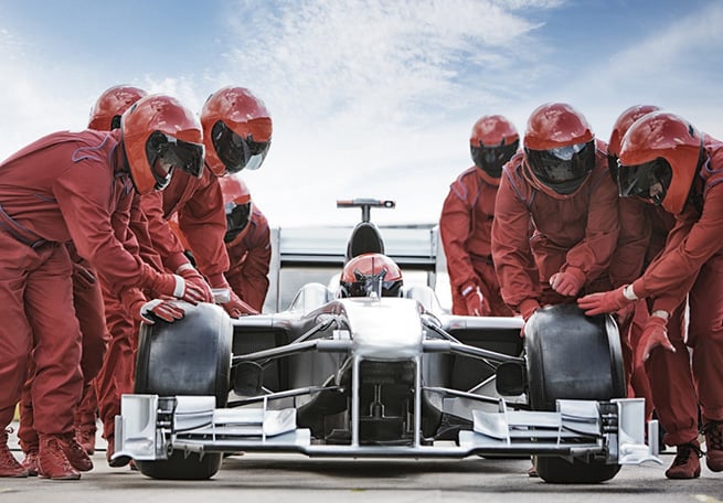 pit crew pushing race car 