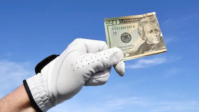 Golfer holding a 20 dollar bill