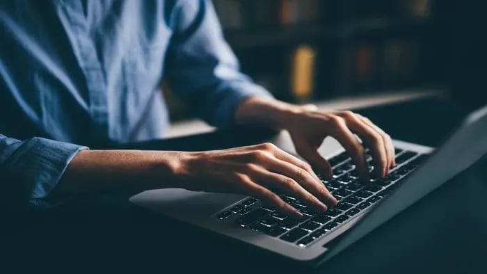 Woman typing on computer keyboard