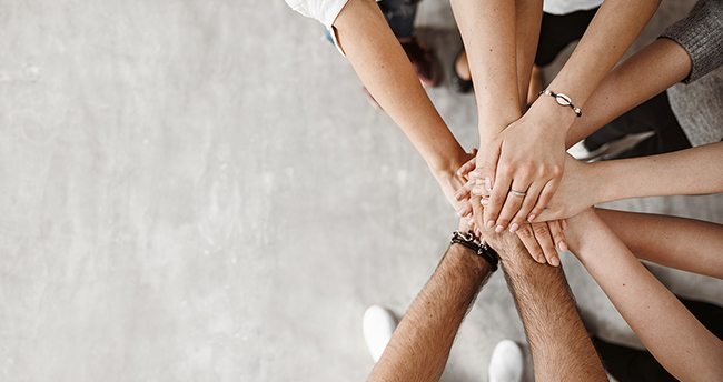 group of people with hand together in a circle